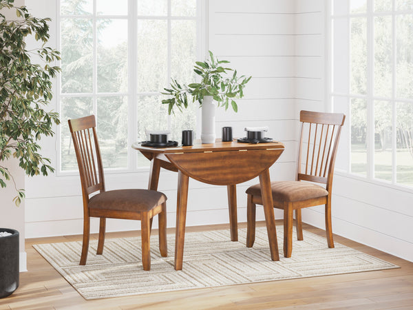 Wooden dining table with two chairs in a bright room with large windows.