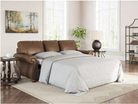 Ashley Chasemoor faux leather sleeper sofa with linens in a room setting.